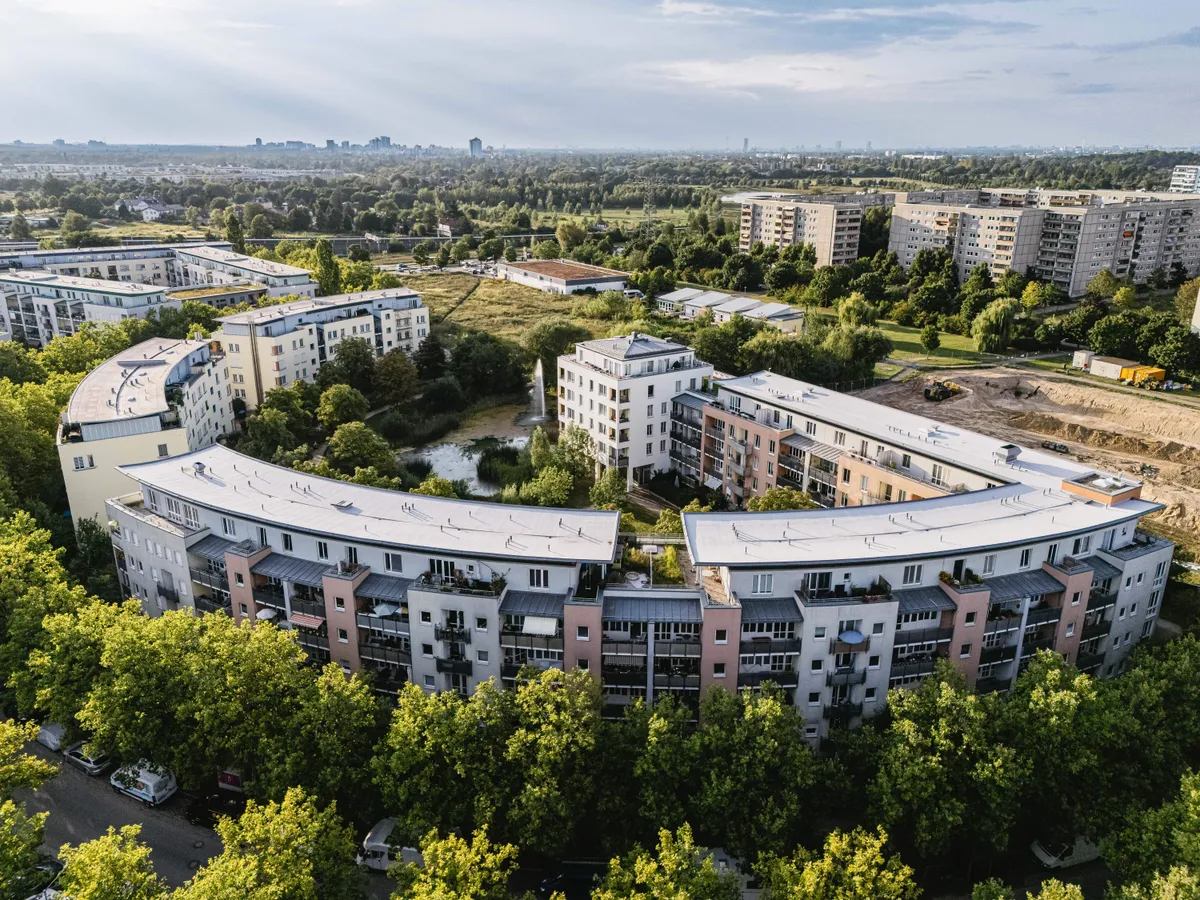 Geschwungenes Wohnquartier mit Teich und Fontäne, Luftaufnahme, Berlin